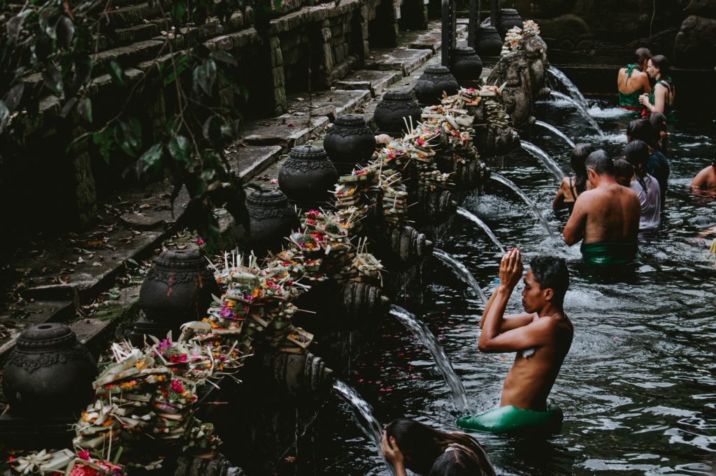 Mensen wassen zich in de Ubud Pura Tirta Empul tempel bij mooiste plekken Bali