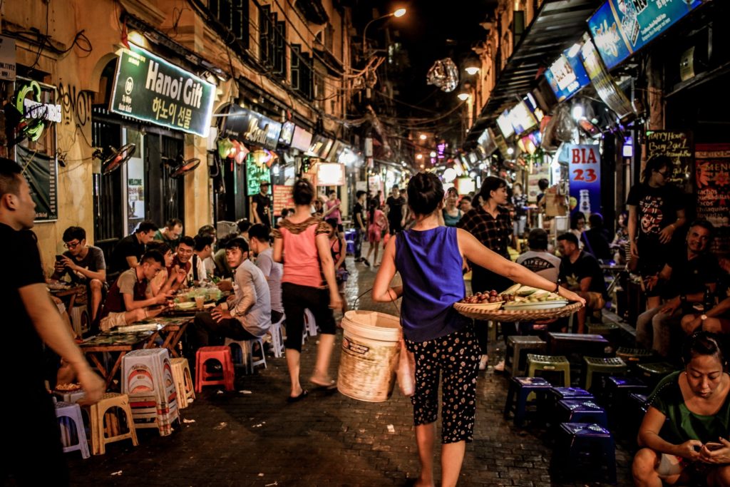 Vrouw loopt door Bia Hoi Corner in Hanoi