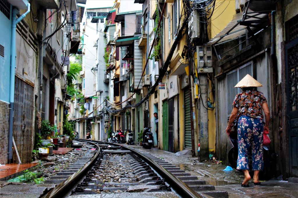 Vrouw loopt door Train Street: een van de bezienswaardigheden in Hanoi in Vietnam